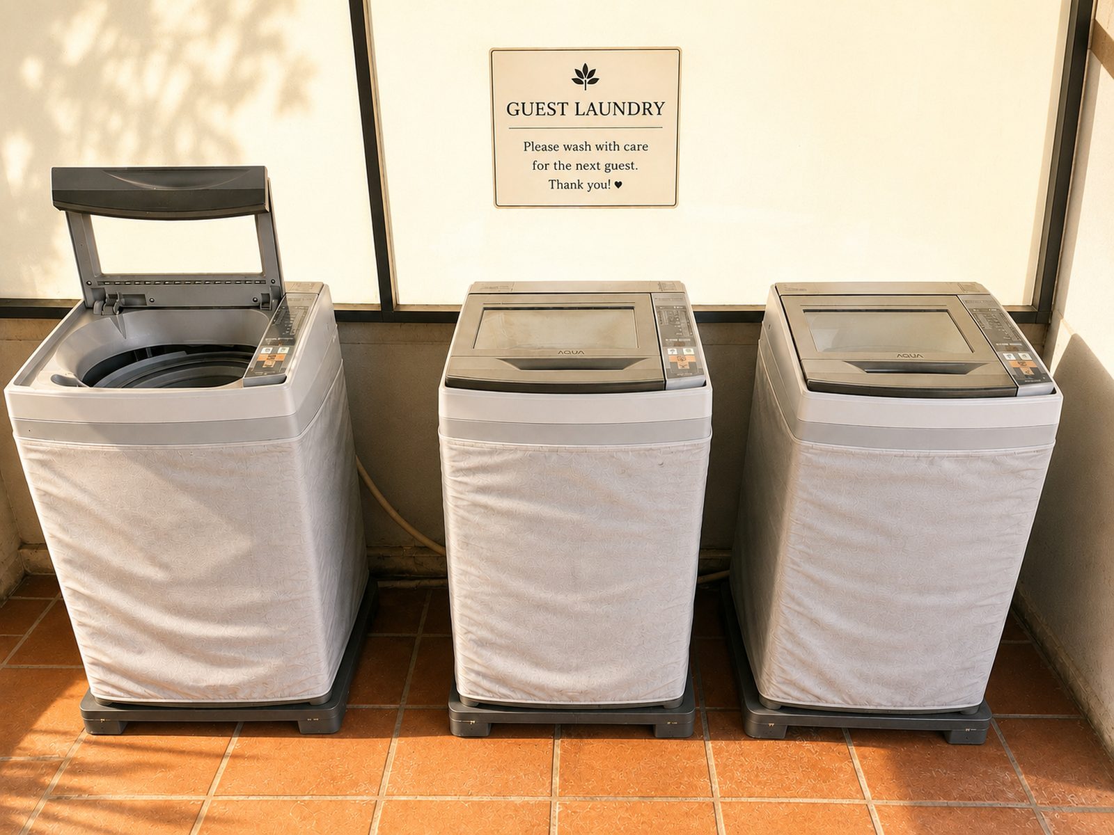Shared guest laundry area with three washing machines